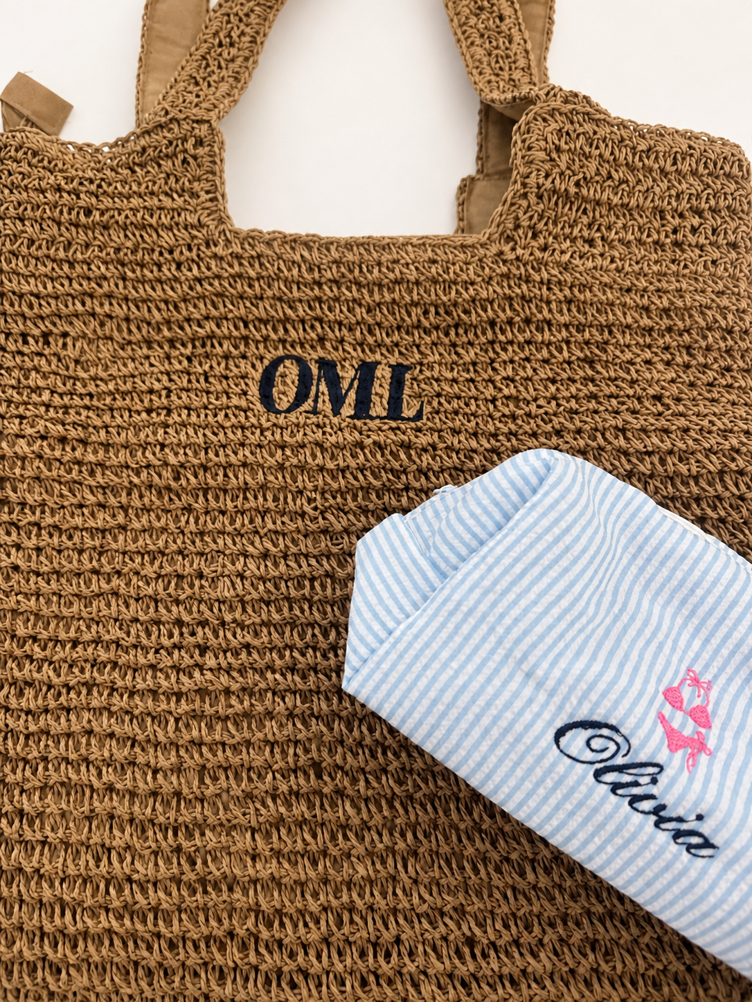 Monogrammed Figstitch straw tote and baby piece photographed in professional studio light