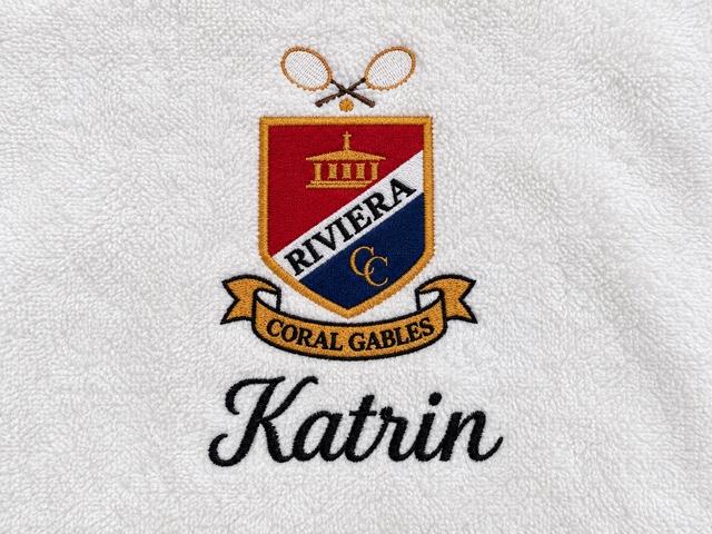 White terry towel with a red, navy and gold Riviera Coral Gables crest, crossed rackets and the name Katrin.